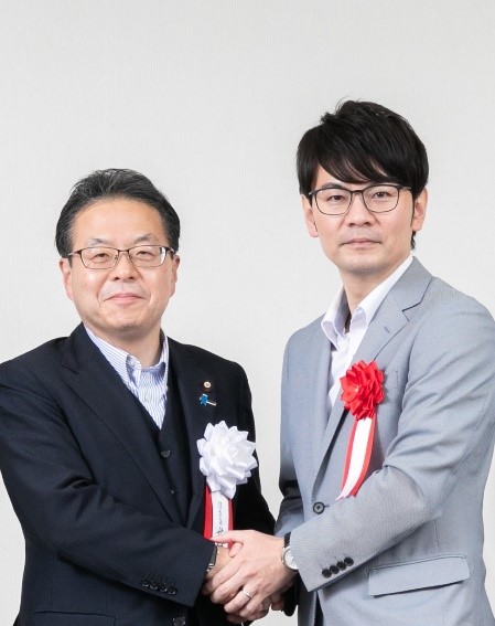 写真：握手する経済産業大臣と代表の木村俊之